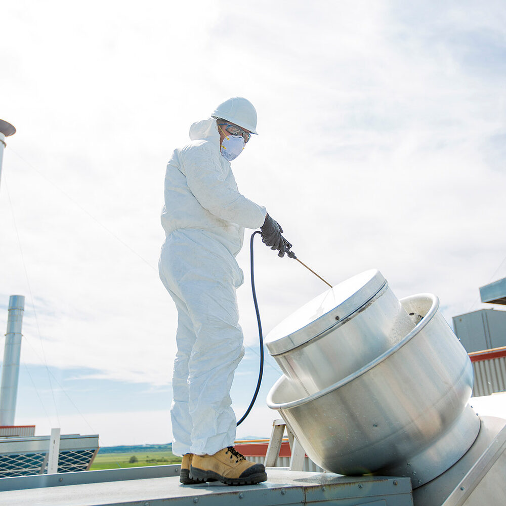 worker spraying facility